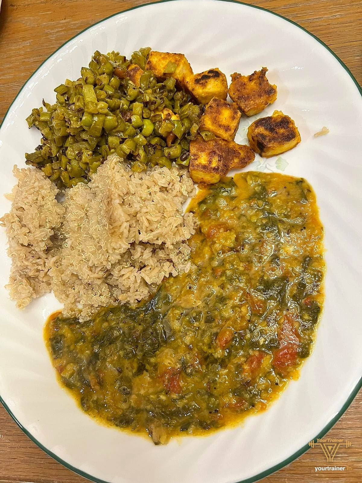 Plate with millet, rice, dal palak, green beans and paneer, a balanced Indian lunch