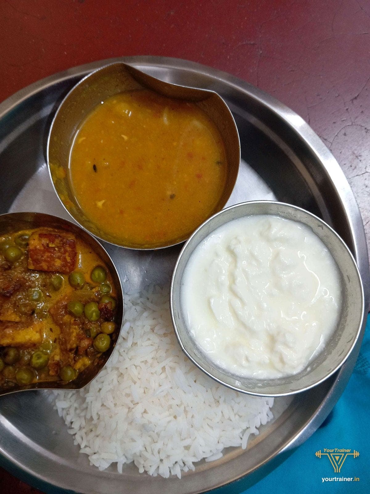 Steel thali with rice, dal, curd and matar paneer