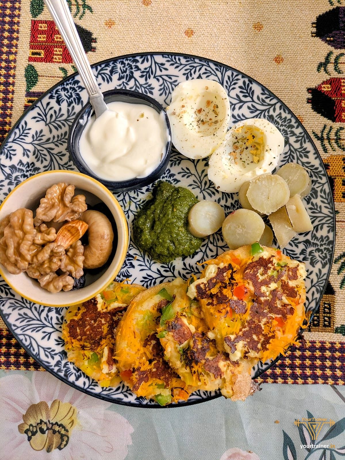 Member plate with boiled eggs, a bowl of curd, walnuts, green chutney, boiled sweet potato and vegetable cheelas