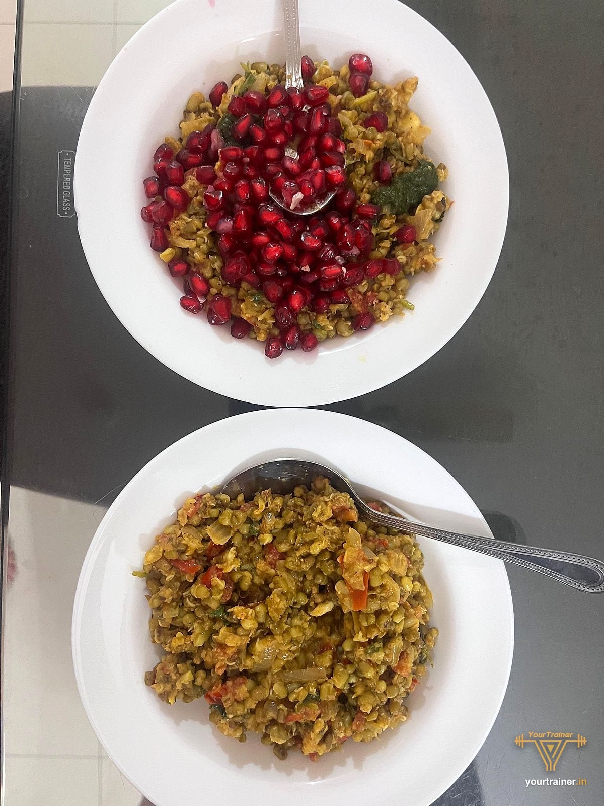 Two bowls of cooked moong sprouts, one topped with pomegranate seeds and green chutney