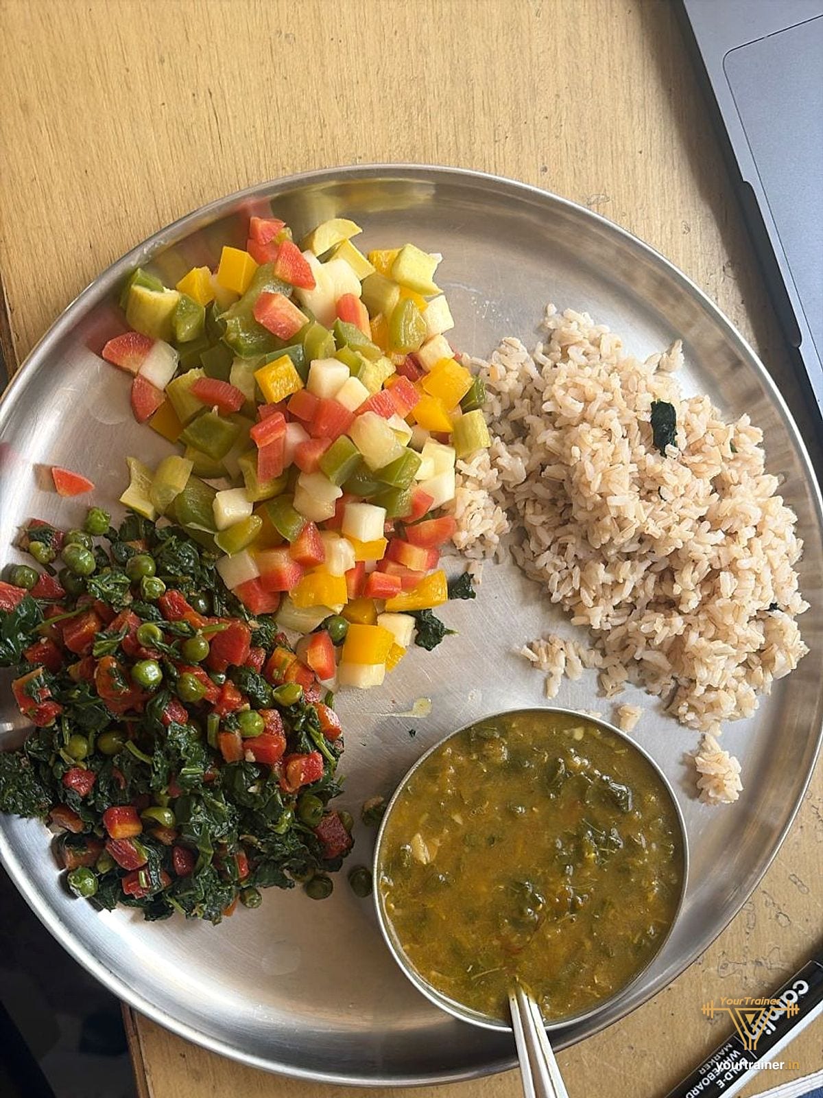 Steel thali with brown rice, dal, palak and peas